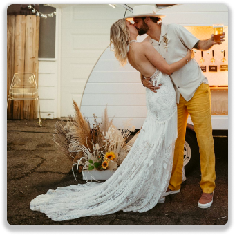 Bride and groom kissing in front of the bar